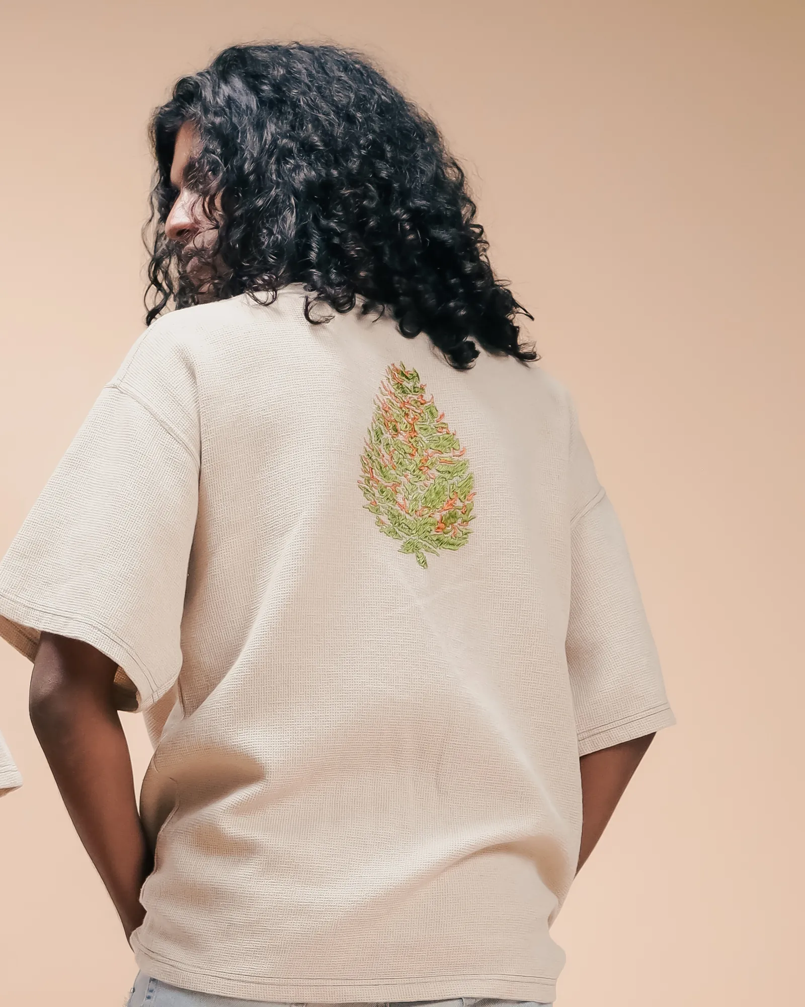 The back of the Pineapple Haze tee, with the embroidered bud between the shoulders