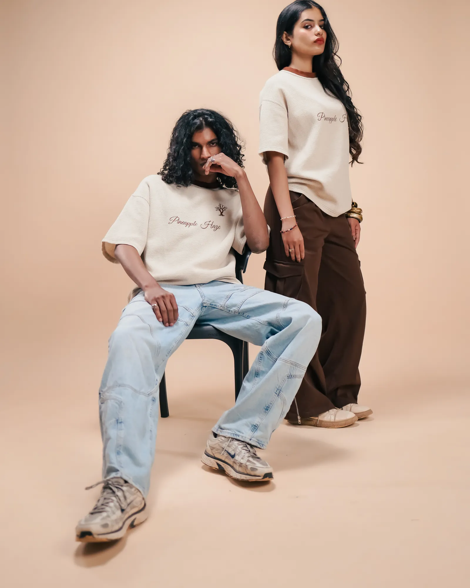 Two people in the Pineapple Haze tee, one seated